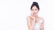 Glamour asian young woman holding white cotton pad removing make-up on white background. Model Asian girl pampering face skin cleaning sponge looking copy space. Healthy skincare and cosmetics concept