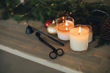 Handmade candle made of soy wax on table with Christmas decorations.