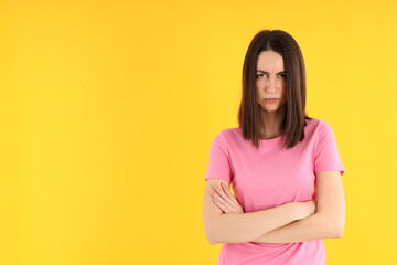 Wall Mural - Young attractive woman in t-shirt on yellow background