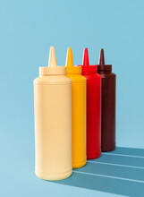 Sauce Bottles Aligned On A Blue Table. Variety Of Sauces.