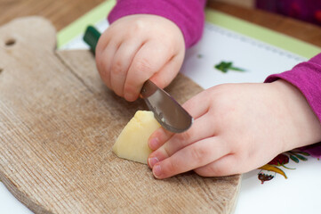 child cutting an apple with a knife