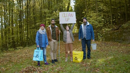 Wall Mural - Diverse group of irritated activists ready to clean up forest, holding banner and looking at camera.