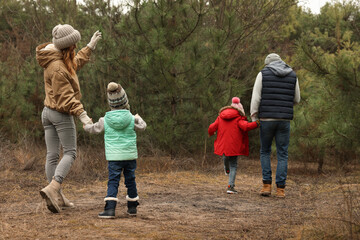 Poster - Happy family spending time together in forest, back view