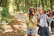 © standret - Front view of kids that is in green forest at summer daytime together