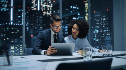 Businesspeople in Modern Office: Business Meeting of Two Managers. Accountant and Operations Director Talk, Discuss, Brainstorm Corporate Strategy, Implementing Budget and Financial Plans. Night.