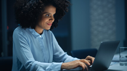 Aufkleber - Successful African American Businesswoman Working on Laptop Computer in Big City Office Late in the Evening. Female Executive Manager Analyzing Financial Reports, Marketing Research and Plans.