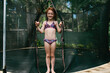 © Austockphoto - Girl standing on a trampoline in a bikini