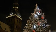 4K - Decorated Holiday Tree Near The Old Clock Tower On Christmas Eve