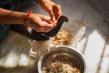 Bengali Indian Woman Cutting Or Dressing Raw Shrimp For Cooking In Desi Cutter Or Boti. Hands Wearing Traditional Bangle.