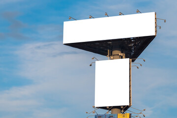 Wall Mural - two blank white billboards or large displays on tower against blue sky with clouds - mock up image. 