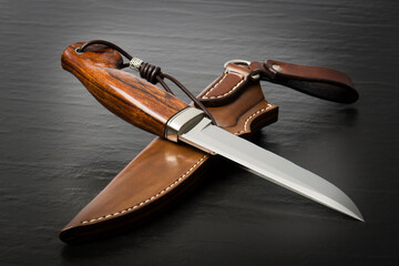 Hunting knife handmade on a black background.