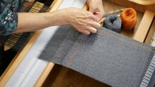 Artisan Finishing The Weaving Project To Stop It From Unraveling. Stitching Work On The End Of The Woven Gray Fabric