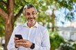© Krakenimages.com - Middle age grey-haired man smiling happy using smartphone at the city.