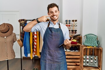 Sticker - Handsome young man working as manager at retail boutique pointing with hand finger to face and nose, smiling cheerful. beauty concept