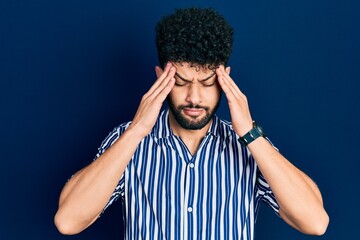 Wall Mural - Young arab man with beard wearing casual striped shirt with hand on head, headache because stress. suffering migraine.