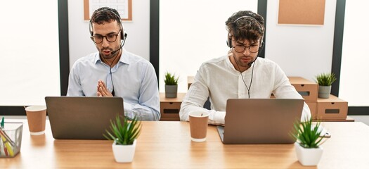 Two hispanic men call center agents smiling confident working at office