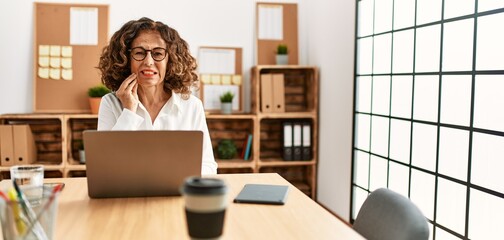 Sticker - Middle age hispanic woman working at the office wearing glasses touching mouth with hand with painful expression because of toothache or dental illness on teeth. dentist