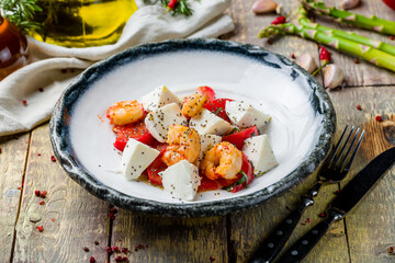 Wall Mural - Caprese salad with mozzarella and tomato and shrimps on wooden table