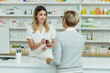 © Zamrznuti tonovi - Female pharmacist selling medications at drugstore to a senior woman customer