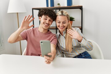 Sticker - Young couple smiling happy making video call using smartphone at home.