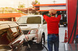 © ฺฺฺBoonterm - Rear view male worker dressed in a red shirt at a gas station is exhausted, with so many cars lined up waiting in line for so many services that they don't have time to take a break