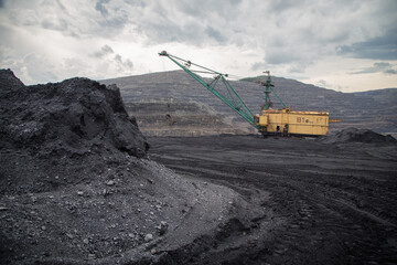 excavator digs coal in the open pit