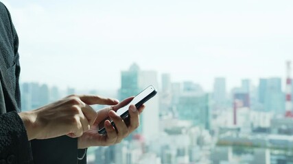 Poster - 都市を背景にスマートフォンを使う男性