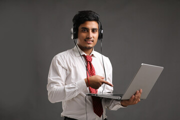 Young indian banker or officer using laptop