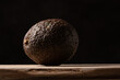 Brown avocado on a wooden table isolated on black background. 