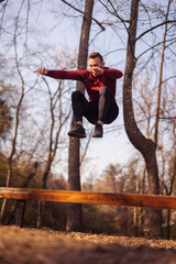 Wall Mural - Man working out outdoors jumping over a bench