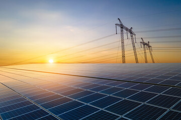 high voltage pylons with electric power lines transfering electricity from solar photovoltaic sells 