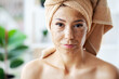 Beautiful young woman with scrub mask in spa salon