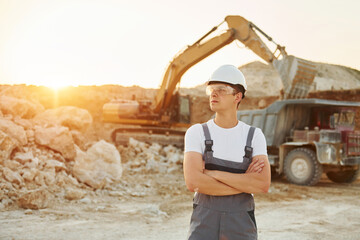 Worker in professional uniform is on the borrow pit at daytime