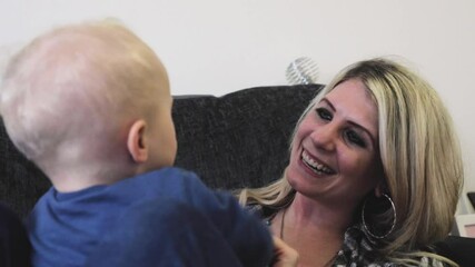 mother playing with her son on the sofa at home