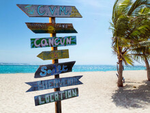 Street Signpost On The Beach Indicating Directions To Different Places Of The World Like Punta Cana In The Dominican Republic And Cancun In The Mexico