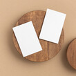 Business cards on a wooden round plate on a beige background - top view, closeup.