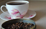 Zdjęcie przedstawiające ziarna kawy z filiżanką
