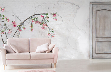 Poster - Pink sofa in the interior. Large potted flowers are a houseplant. Light stylish modern interior.