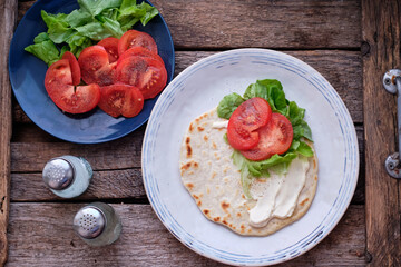 Sticker - Flatbread with sauce, tomato, lettuce. Wooden background, top view