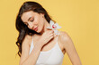 © ViDi Studio - Attractive young tender nice beautiful brunette woman 20s wearing white underwear brassiere hold in hand flower isolated on plain yellow color background studio portrait. People female beauty concept