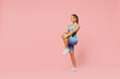 © ViDi Studio - Full size young sporty athletic fitness trainer woman wear blue tracksuit spend time in home gym train do stretch legs exercise isolated on pastel plain light pink background. Workout sport concept.