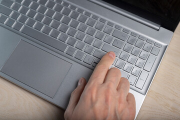 Poster - Hand on laptop keyboard, tapping and pressing button with finger closeup.