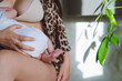 Beautiful mother in beige bra and leopard robe breastfeeding her newborn baby 
