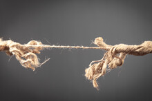 Frayed Rope About To Break On Grey Background. Risk