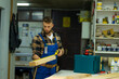 © DusanJelicic - Portrait of young handsome caucasian carpenter who measures a board at the workshop