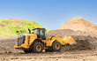 Yellow wheel loader on the road construction site