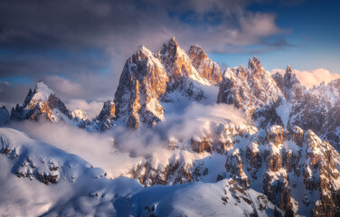 Wall Mural - beautiful mountain peaks in snow in winter at sunset. colorful landscape with high snowy rocks in fo