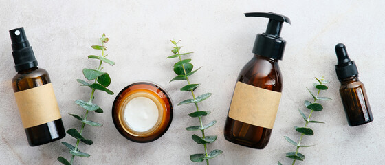 Wall Mural - natural organic cosmetics in amber glass bottles in row on stone table with eucalyptus. beauty blog 