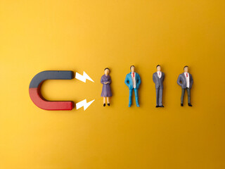 businessman attracts by magnet on a yellow background. business and leadership concept.
