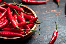 Wooden Plate With Hot Chili Peppers. On A Rustic Dark Background. High Quality Photo